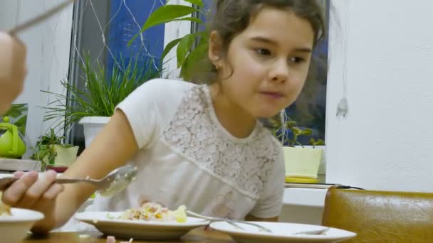 Teen girl eats food hungry lettuce at table — Stock Video