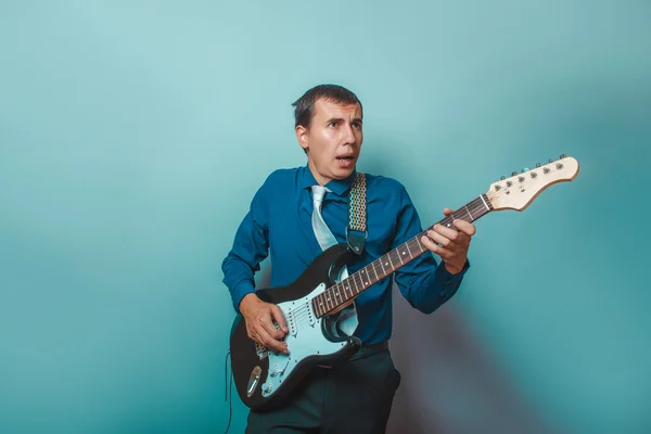 A man of European  appearance thirty years of playing the guitar — Stock Photo, Image