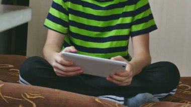 kanepede oturan tablette oynayan erkek genç