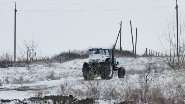 Traktor wsuwa tkwi w śniegu na drodze zima — Wideo stockowe
