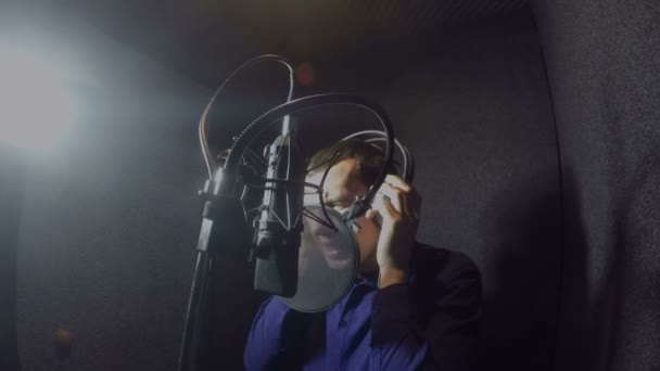 Hombre cantante en auriculares cantando canción en estudio — Vídeo de stock