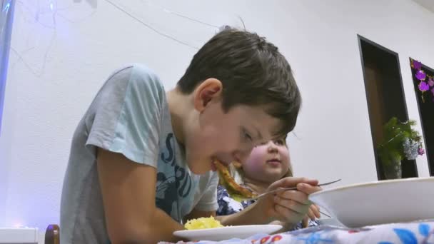 Menino adolescente na mesa comer carne cortar férias com batatas — Vídeo de Stock