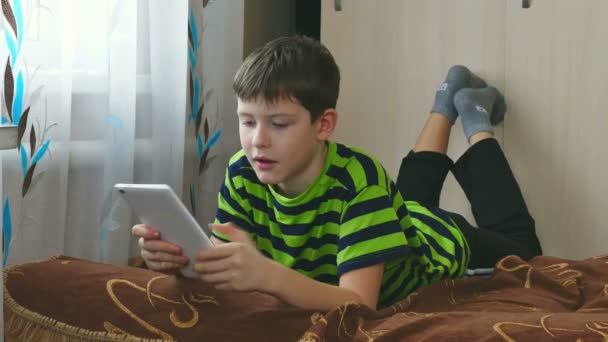 Chico adolescente jugando en tableta internet navegación jugando un juego — Vídeo de stock