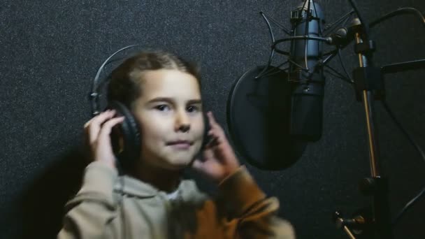 Κορίτσι τραγουδώντας σε ένα επαγγελματικό στούντιο ήχου μουσικής μικρόφωνο ακουστικά — Αρχείο Βίντεο