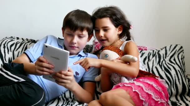 Menino jogando em tablet menina jogando com bonecas — Vídeo de Stock