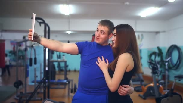 Hombre y mujer en un gimnasio haciendo uno mismo en la tableta atletas deportes simuladores — Vídeo de stock