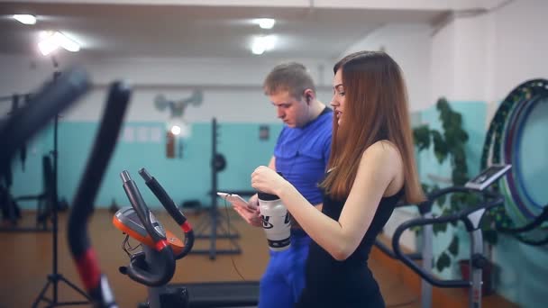 Flicka idrottsman dricksvatten tröttnar i gym utbildare sport — Stockvideo