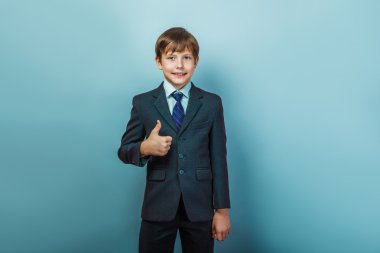 a  boy of twelve  European appearance in a suit  thumbs up on a