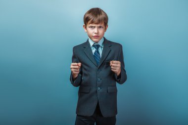 a  boy of twelve European appearance in a suit thumbs up on a gr