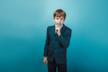 a boy of  twelve European appearance in a suit  finger on the li