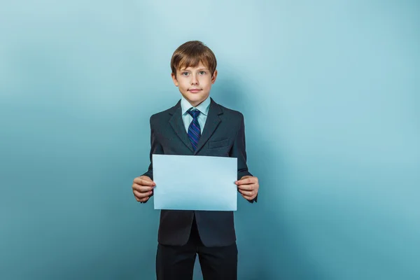 A  boy of twelve European appearance in a suit  holding a blank — Stock Photo, Image