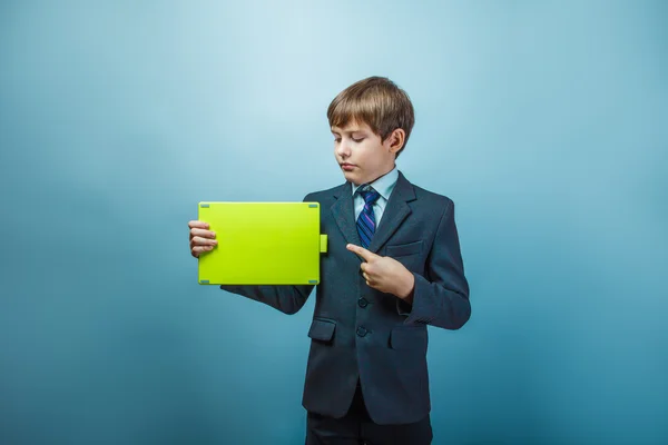 Teen boy of twelve  European appearance in a business suit holdi — Stock Photo, Image