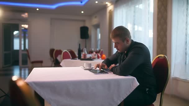 Homem com o seu tablet freelance no café beber internet café — Vídeo de Stock