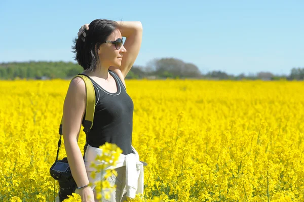 Kvinna bland blommande rapsfält. — Stockfoto