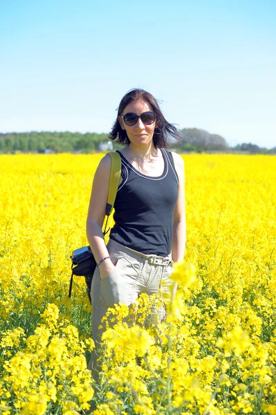 Frau inmitten blühender Rapsfelder. — Stockfoto