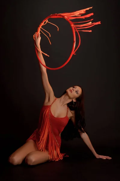Sexy Brunetka Czerwonym Garniturze Gimnastyczne Obręcz Ciemnym Tle Studio — Zdjęcie stockowe