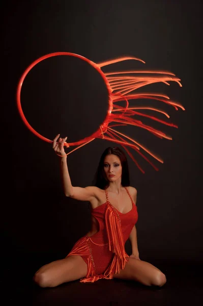 Sexy Brunetka Červeném Obleku Gymnastickou Obručí Tmavém Pozadí Studiu — Stock fotografie