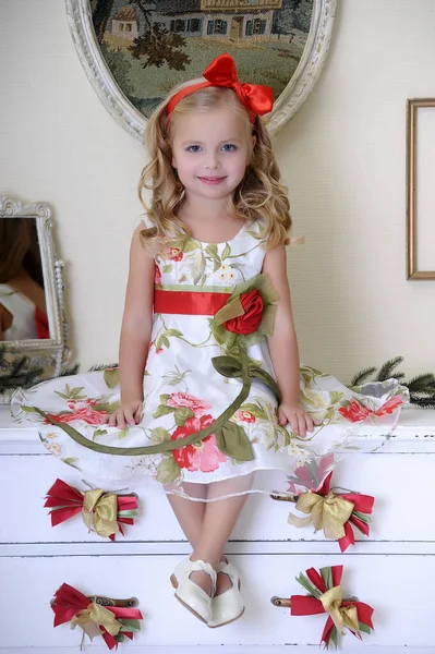 Μικρή Όμορφη Ξανθιά Κοπέλα Μπούκλες Κάθεται Λευκό Ένα Κόκκινο Φόρεμα — Φωτογραφία Αρχείου