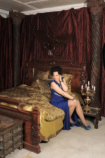 Mavi Elbiseli Esmer Kadın Eski Moda Çamaşırlı Yatakta — Stok fotoğraf