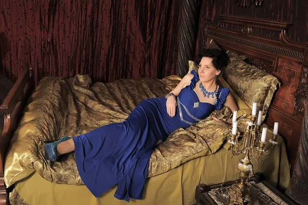 Brünette Dame Blauen Kleid Auf Dem Bett Vintage Interieur — Stockfoto