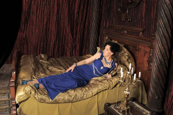 Brünette Dame Blauen Kleid Auf Dem Bett Vintage Interieur — Stockfoto