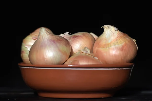 Onions in a bowl on a table — Stock Photo, Image