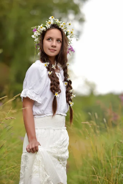 Flicka med flätor och prästkragar i håret. — Stockfoto