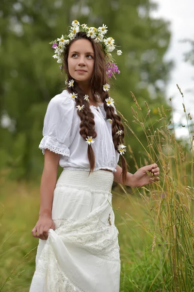 Flicka med flätor och prästkragar i håret. — Stockfoto