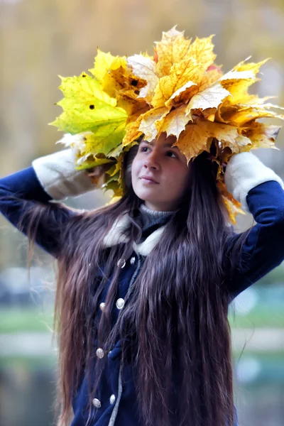 Κορίτσι με ένα στεφάνι από φθινόπωρο αφήνει στο κεφάλι — Φωτογραφία Αρχείου