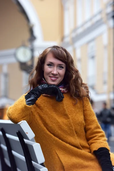 Elegante vrouw in de oranje herfst jas — Stockfoto