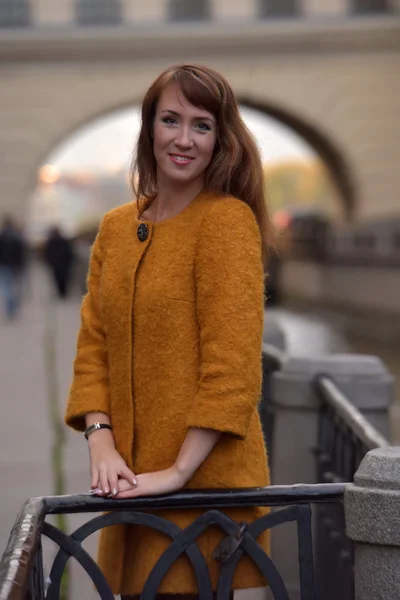 Элегантная женщина в оранжевом осеннем пальто — стоковое фото
