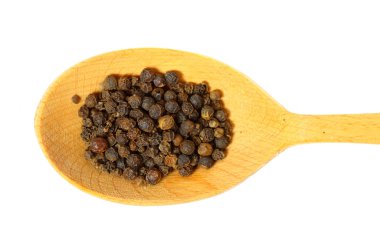 Bir tahta kaşık üzerinde kara biber tohumları. beyaz izole