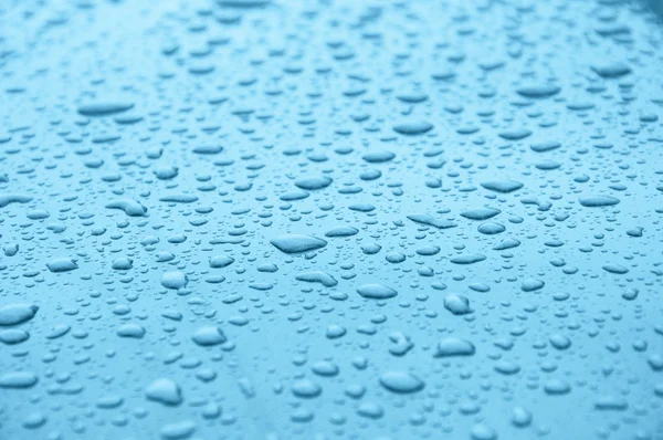 Gotas de agua en una superficie azul claro — Foto de Stock