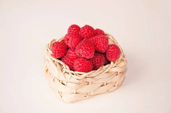 Framboises dans un panier blanc au milieu — Photo