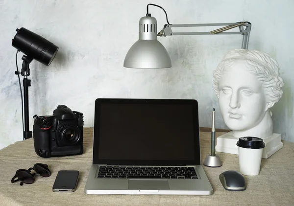 Lugar de trabajo fotógrafo independiente. Set de herramientas Fotógrafo: ordenador portátil, cámara, cabeza, pluma, teléfono, ratón, gafas . — Foto de Stock