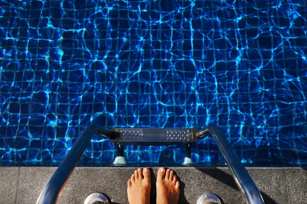 Voeten van de bovenste voorkant van het zwembad met blauw water — Stockfoto