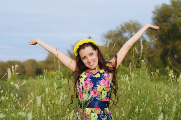 Happy vacker kvinna med krans av blommor på huvudet — Stockfoto