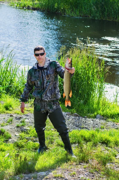 De visser met de gevangen snoek — Stockfoto