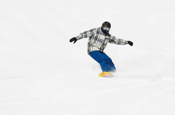 Een snowboarder komt van de helling van de berg — Stockfoto