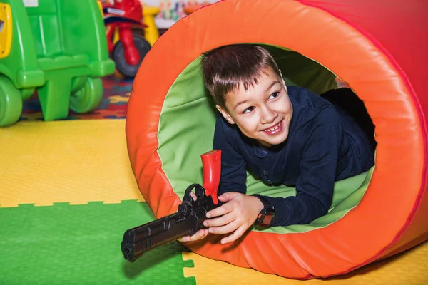 Cheerful Boy Having Fun Lying Floor Toy Gun His Hands — Stock Photo, Image