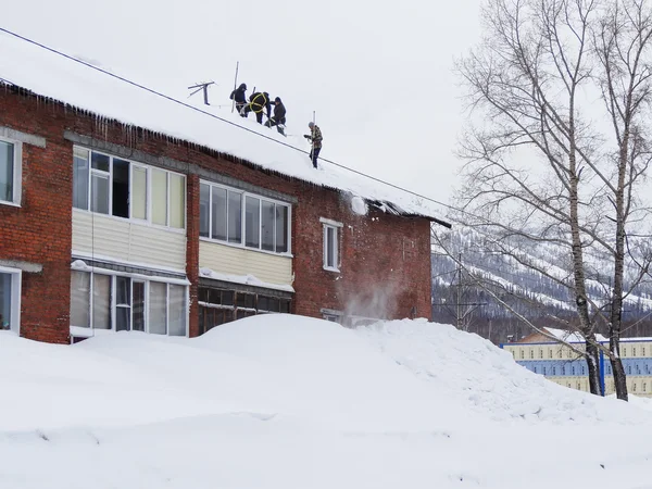 Clearing the snow from the roof of the house — Stock Photo, Image