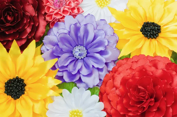 Vícebarevné pozadí z umělých květin — Stock fotografie