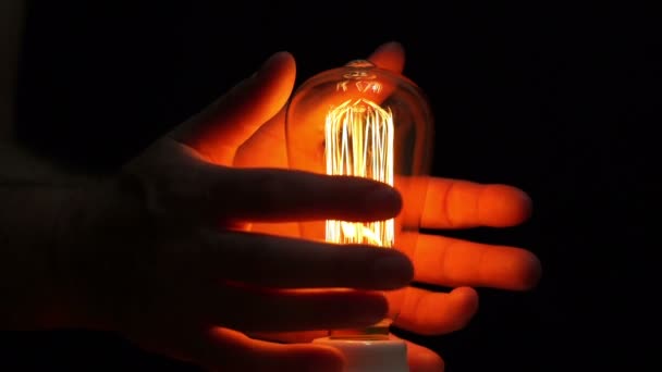 Man antieke Filament lamp handen opwarming van de aarde kant — Stockvideo