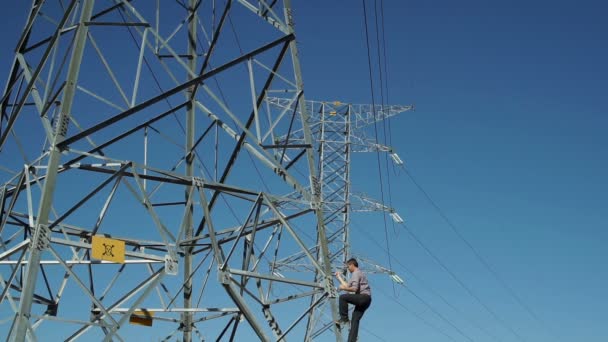 Escalada masculina Torre eléctrica de alta tensión — Vídeos de Stock