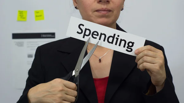 Une femme d'affaires réduit son concept de dépenses Images De Stock Libres De Droits