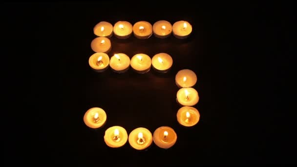 Зажженная свеча номер пять — стоковое видео