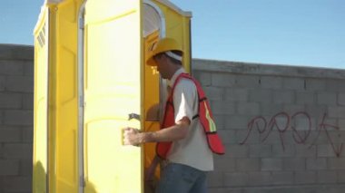 Erkek inşaat işçisi taşınabilir banyo yakın