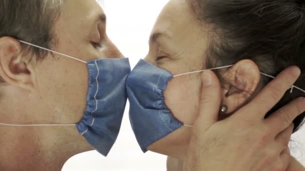 Pareja usando máscaras médicas besándose — Vídeo de stock