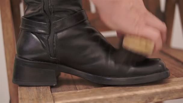 Жінка чистить високий чоботи всередині ноги — стокове відео