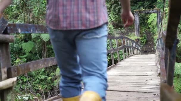 Homem anda na ponte pendurada vai — Vídeo de Stock